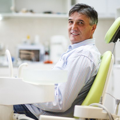 Man smiling while sitting in treatment chair