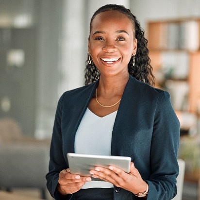 Smiling woman holding tablet in office