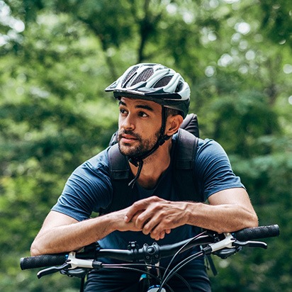 Man with helmet riding bike outside